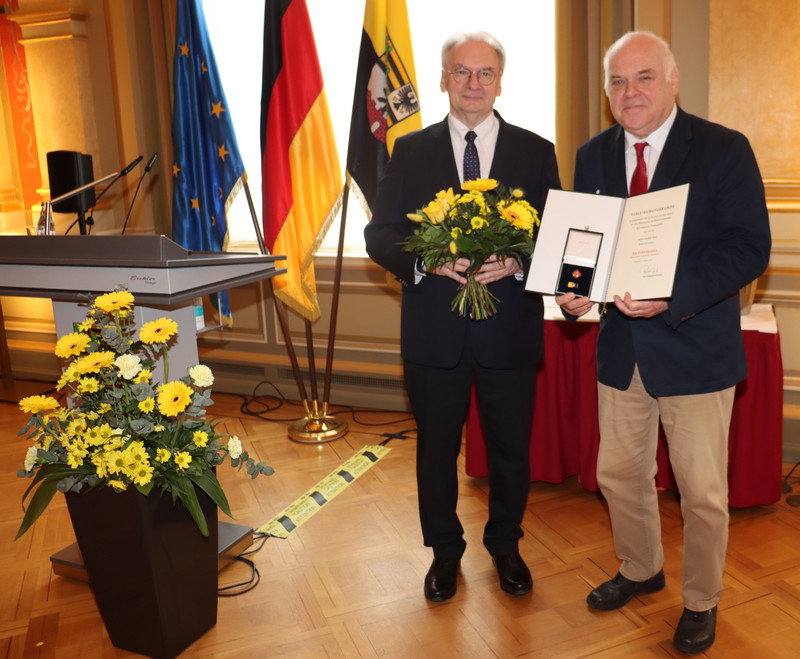 Das Bild zeigt Ministerpräsident Dr. Reiner Haseloff (links) und Konrad Reiß mit Urkunde und Ehrennadel.