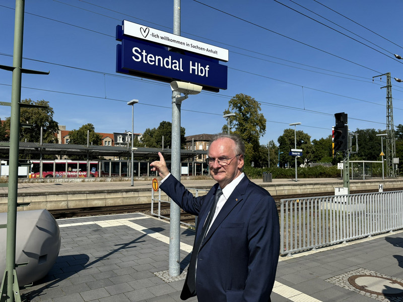 Das Bild zeigt Ministerpräsident Dr. Reiner Haseloff vor dem neuen Bahnhofschild in Stendal.