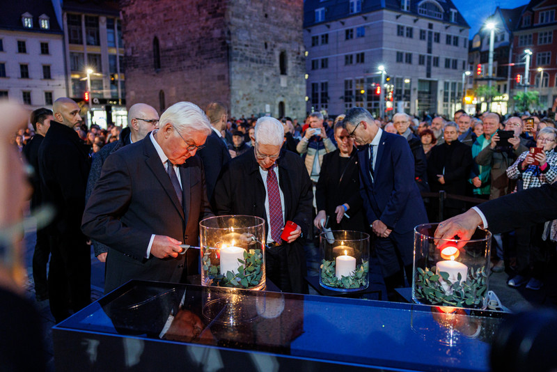 Bundespräsident Frank-Walter Steinmeier entzündet eine Kerze auf dem Marktplatz Halle.